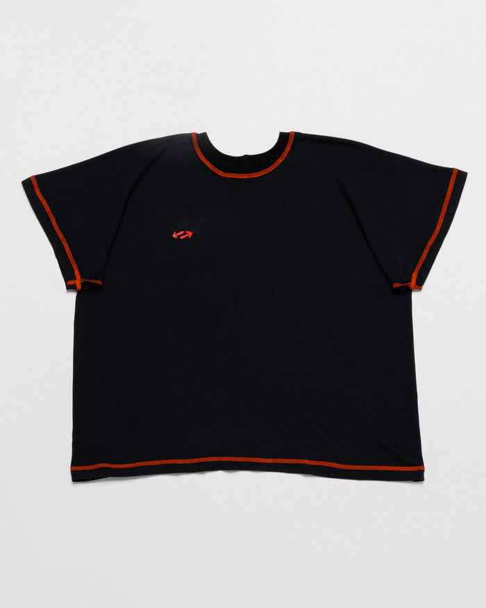 Outnback Bog Tee in black, front flat lay with contrast orange stitching and red arrow logo