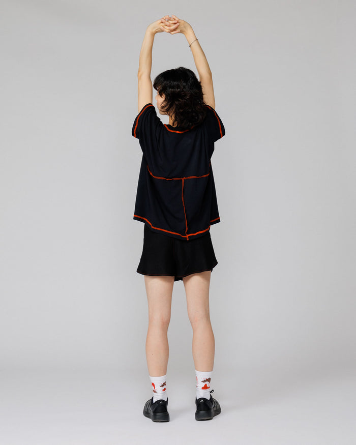 Outnback Running Short in black, back view on model mid-stretch
