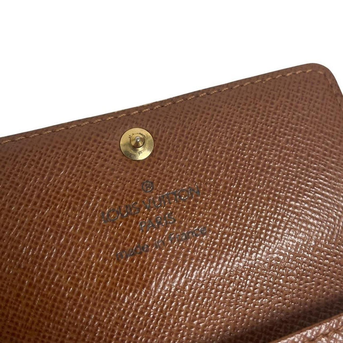 Louis Vuitton brown and tan monogram canvas key case with logo detail.