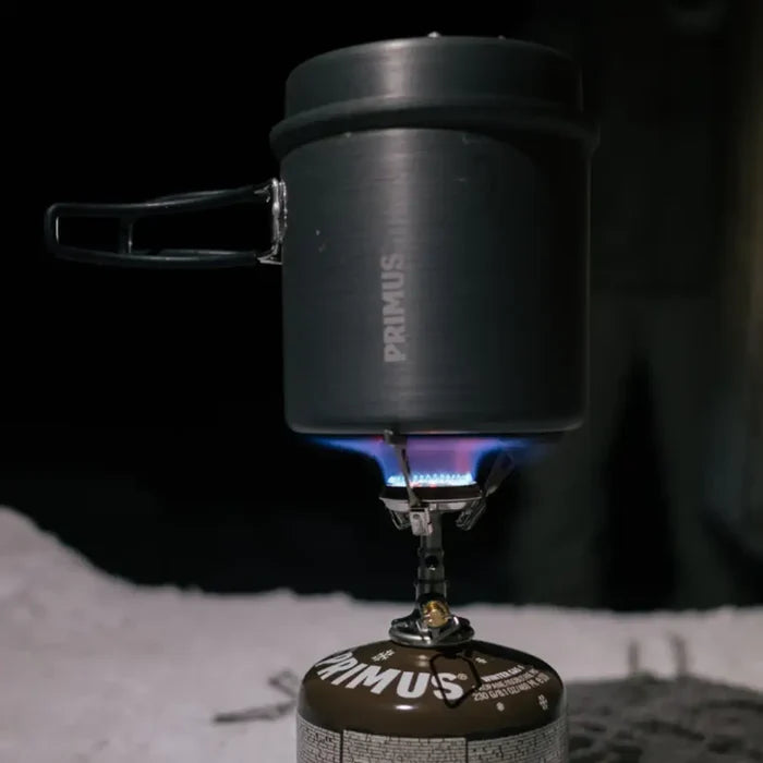Primus Litech trek kettle ontop of a lit portable gas camping stoive in the snow