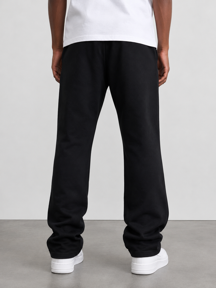 Black Protector and Maintainer FTMH heavyweight stacked sweatpants laid flat showing the fabric texture and design details.