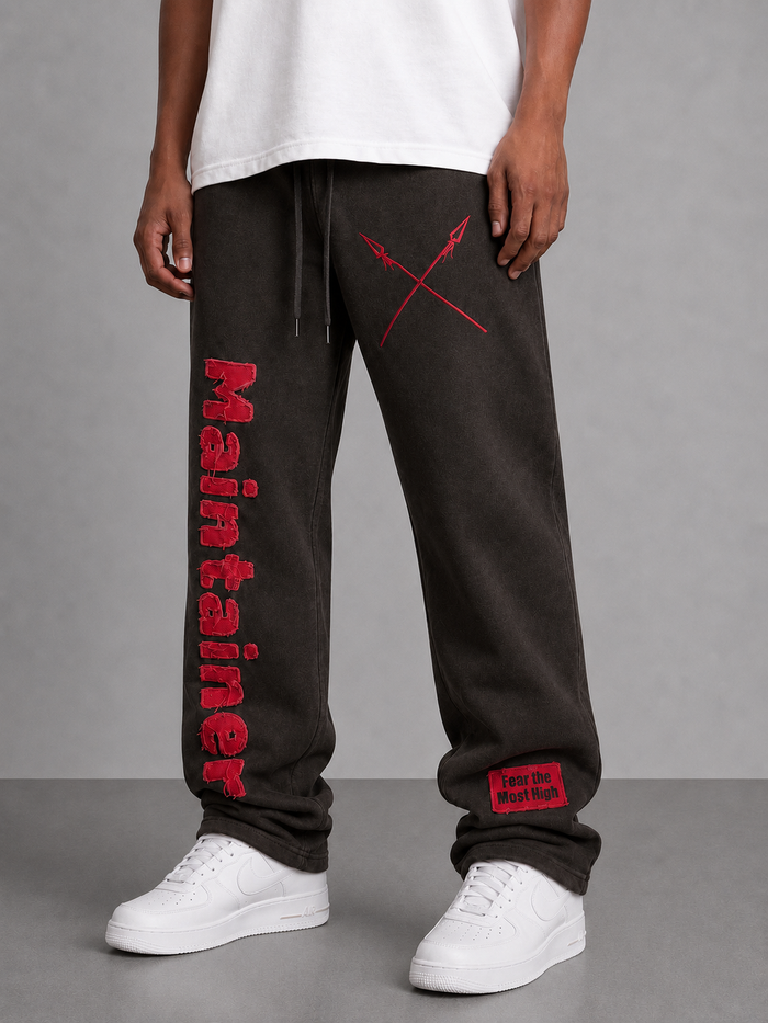 Copper black Protector and Maintainer FTMH heavyweight stacked sweatpants displayed on a hanger.