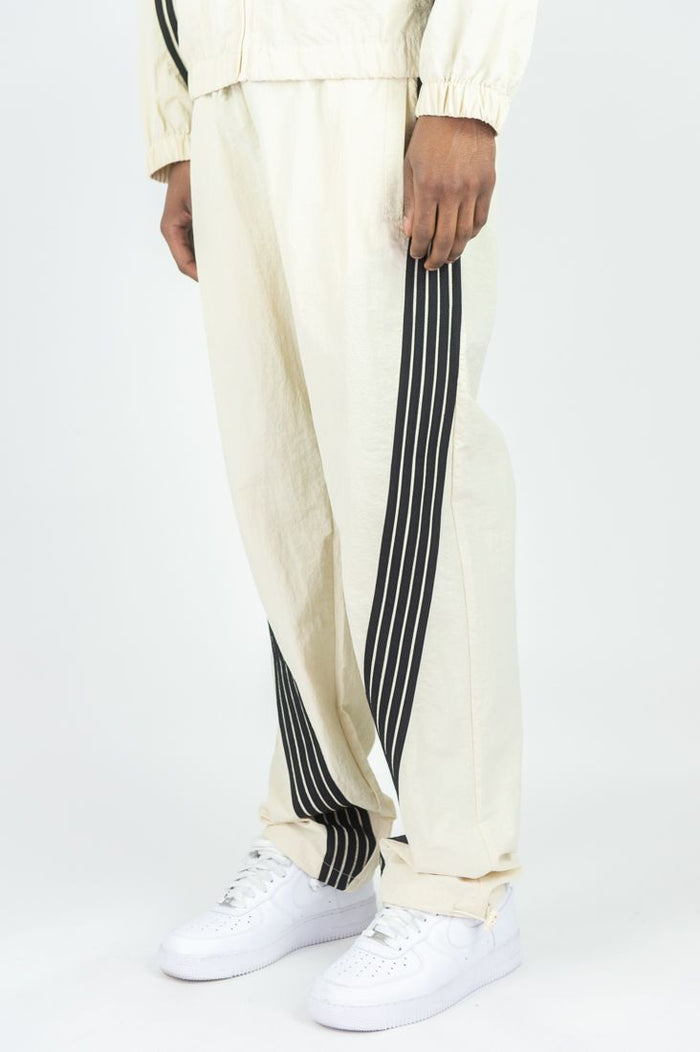 Rebel Minds Bent Stripes cream nylon sweatpants with relaxed fit and stripe design, casual athletic style.