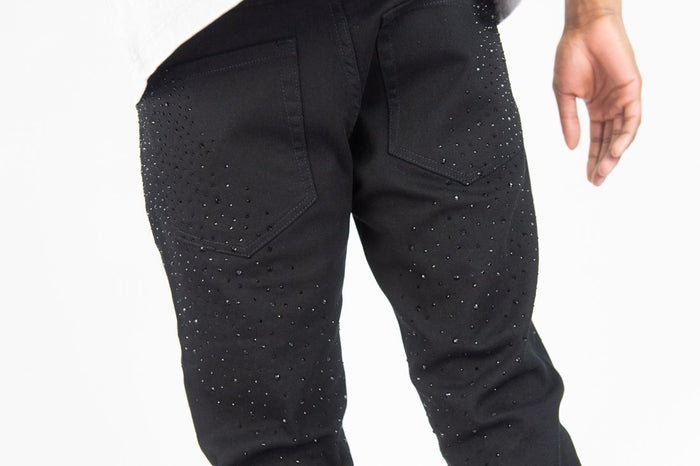 Black stacked flare denim jeans by Roar Denim with rhinestone embellishments, featuring a stylish jet black color.
