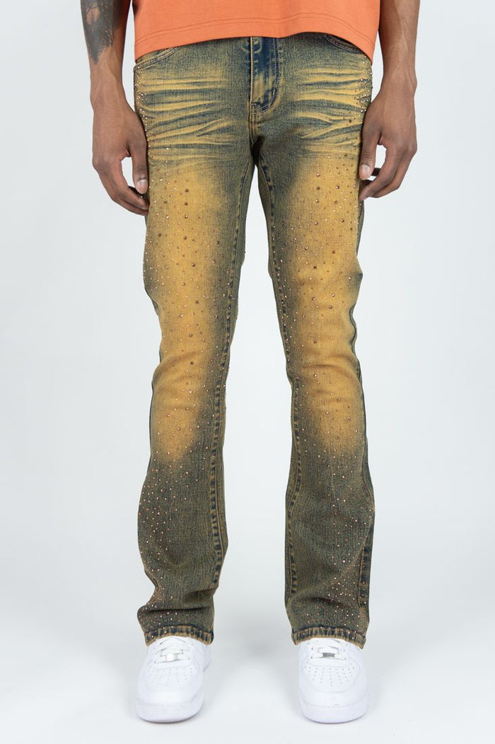 Rust-colored Roar Denim stacked flare jeans with rhinestone embellishments and a high-rise fit, showcasing the denim's textured details.