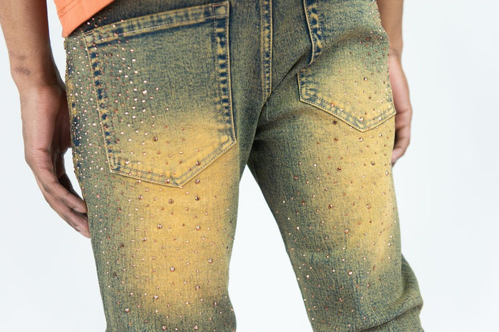 Rust-colored Roar Denim Rhinestone Stacked Flare Denim jeans with a fitted waist and flared legs, detailed with rhinestone embellishments.