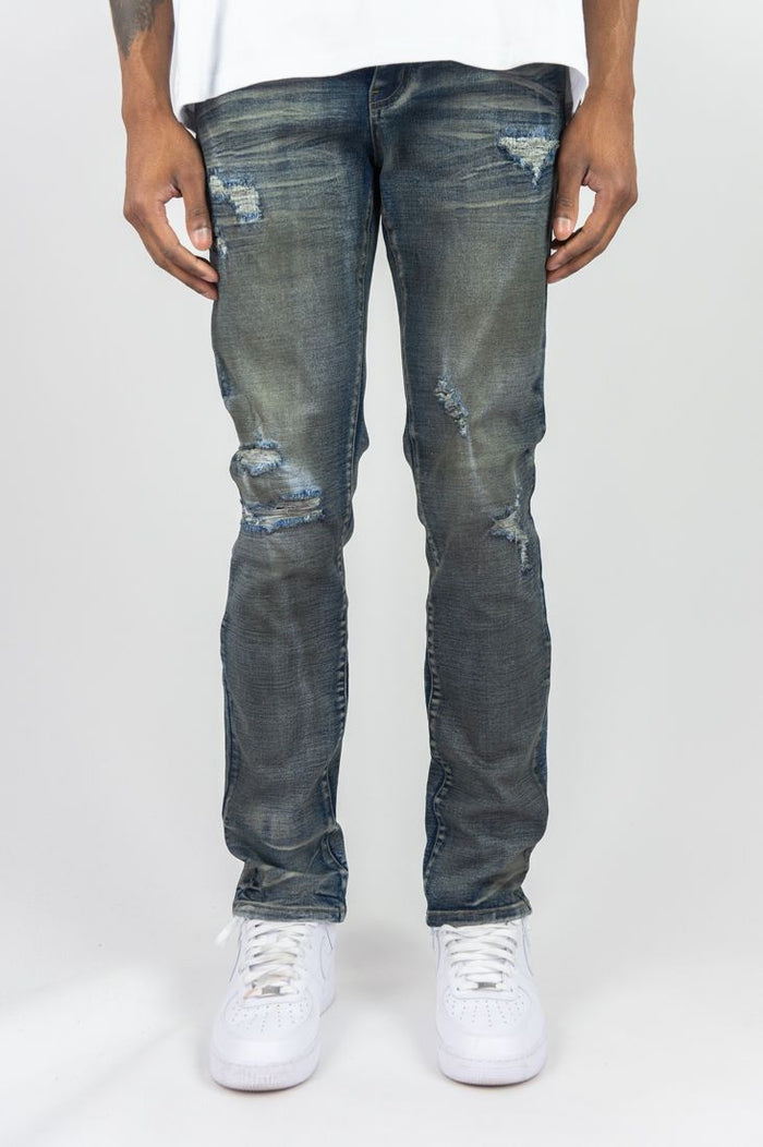 Dark vintage Roar Denim R&R slim straight denim jeans displayed on a hanger with a blurred background.