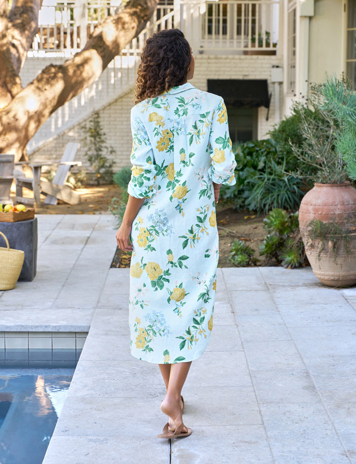 Woman in a floral dress standing by a poolside