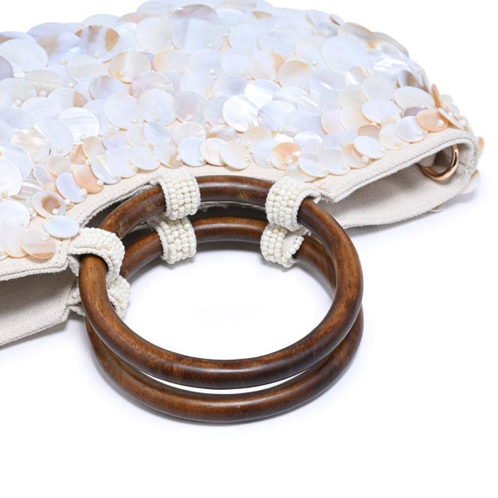 Close-up of the Scarlett Evening Bag's polished wood ring handles with hand-beaded wraps and layered iridescent shell disc embellishments.