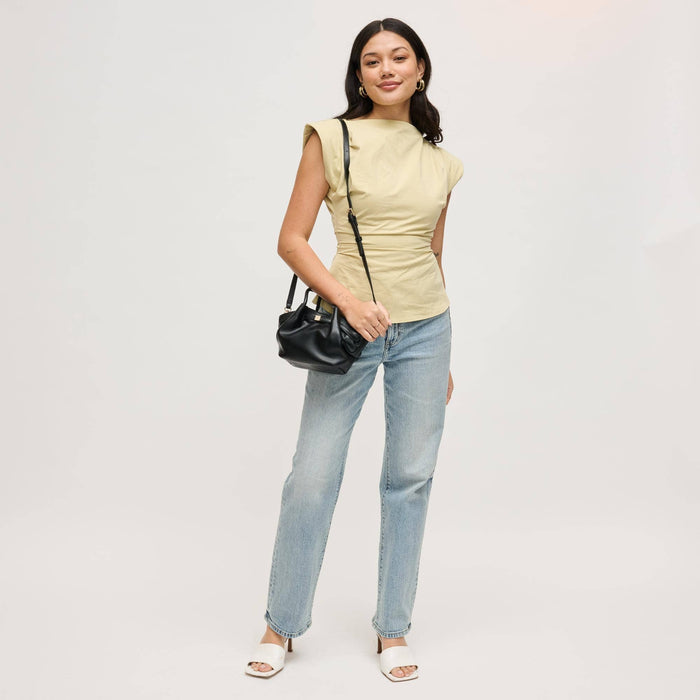 Model styling the Selena Crossbody with casual denim and a neutral top, highlighting its versatile black vegan leather design and adjustable crossbody strap.