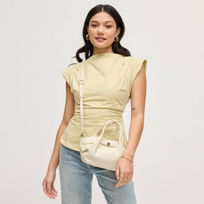 Model styling the Selena Crossbody in cream as a crossbody with casual denim and a neutral top, highlighting its elegant gathered shape and adjustable strap.