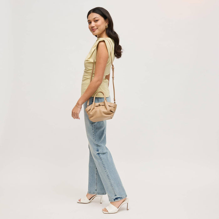 Side view of the Selena Crossbody in taupe vegan leather worn crossbody, highlighting the adjustable strap and compact everyday silhouette.