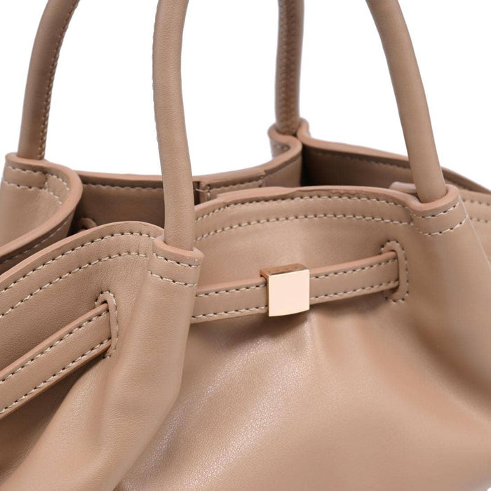 Close-up of the Selena Crossbody showcasing the taupe vegan leather, gathered construction, precise stitching, and gold-tone hardware detail.