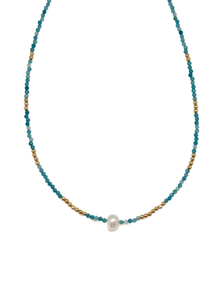 Sera Apatite Necklace with faceted blue apatite beads, gold accents, and a single center pearl on white background.