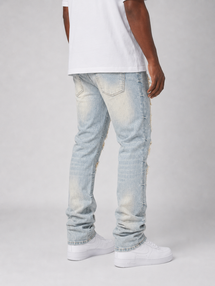 Smoke Rise Aim High tapestry applique denim stack in Seville Blue, featuring intricate design and textured denim fabric.