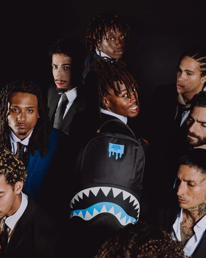 Sprayground Shark Central Passport Blue backpack with shark graphic, featuring adjustable straps and multiple compartments.