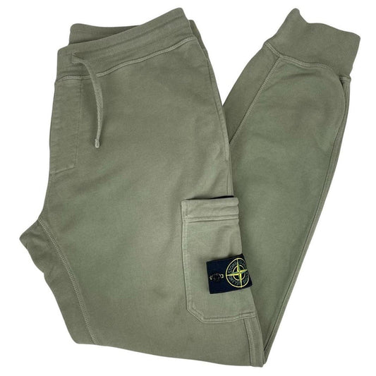 Stone Island green joggers with logo patch and cotton material, visible wear marks.