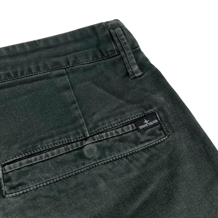 Stone Island green slim fit cotton trousers with logo patch and faded details.