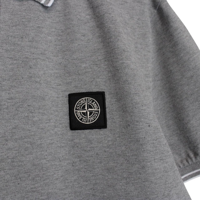 Stone Island grey polo shirt with embroidered compass logo and cotton material.