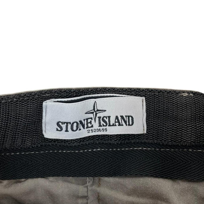 Stone Island beige slim fit cotton trousers with logo patch and visible wear marks.