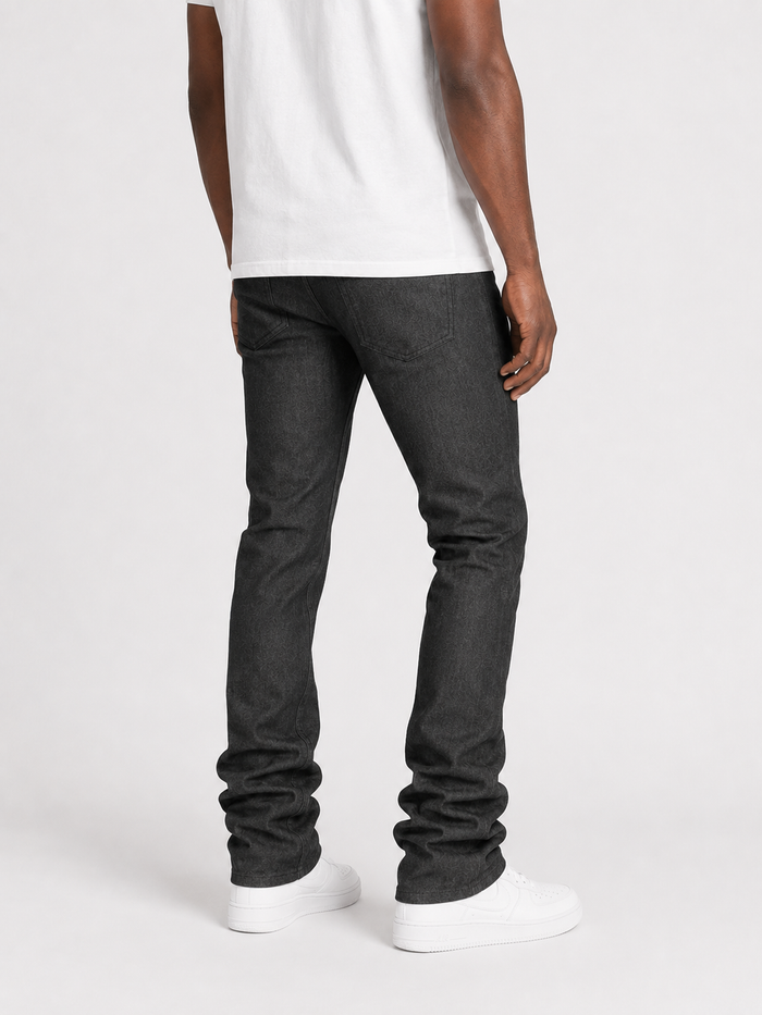 Taker Raw Fabric Stack Denim in Raw Black showing stacked raw black denim fabric with selvage edges and textured surface.