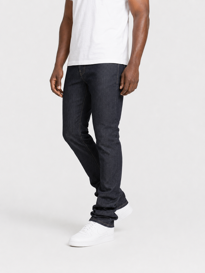 Taker Raw Fabric Stack Denim in raw indigo, showcasing stacked folded denim with visible raw edges and deep blue color.