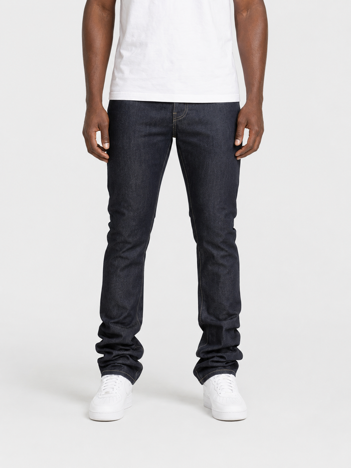 Taker Raw Fabric Stack Denim in raw indigo, showcasing folded raw denim jeans with visible stitching and fabric texture.