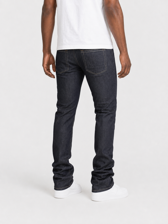 Taker Raw Fabric Stack Denim in Raw Indigo, showing folded raw denim with a textured, rugged appearance and natural fade details.