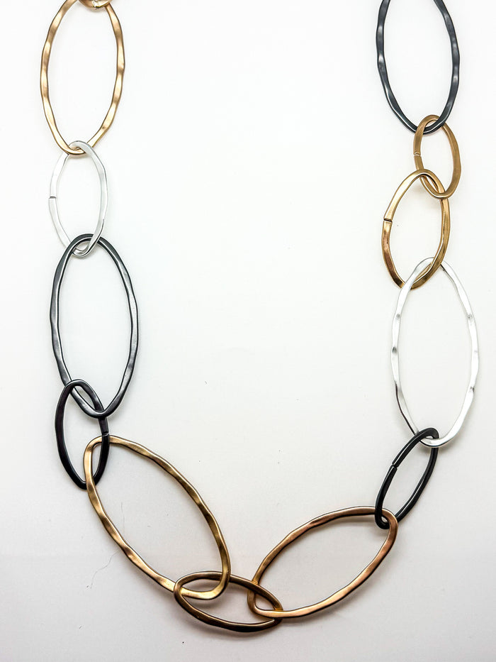 Necklace with interlocking oval links in gold, silver, and black on a white background