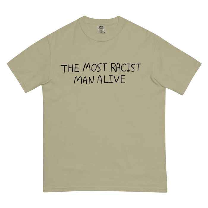 The Most Racist Man Alive T-Shirt - The crude, hand-scrawled "THE MOST RACIST MAN ALIVE" text in marker black (#080808) contrasting against the stone grey (#B1B3B4) backdrop.