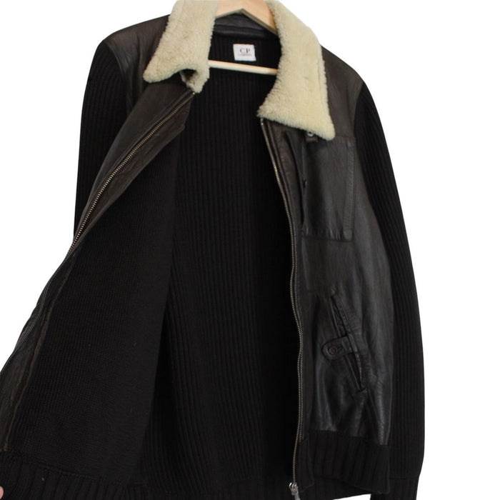 CP Company brown leather and wool shearling jacket with vintage design and logo details.