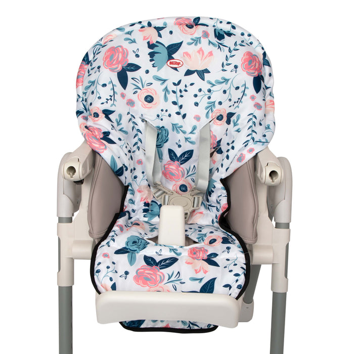 The Nuby Water-Resistant High Chair Cover features pink and navy blue flowers with green leaves on white, is machine washable, and fits a chair with a safety harness and beige plastic armrests.