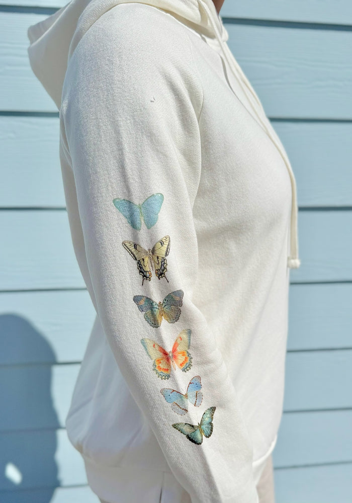 White hoodie with colorful blue butterfly designs on a light blue background