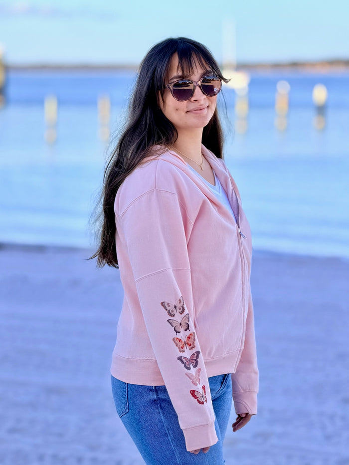 woman wearing red and pink butterfly zip beach in background