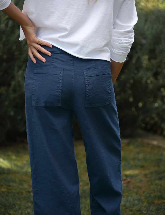 Person wearing blue pants with a blurred natural background