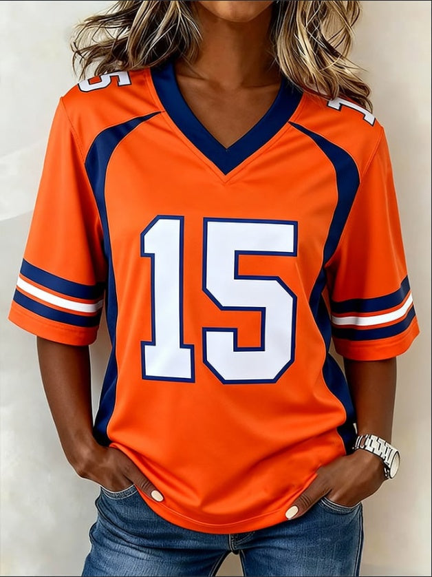 Person wearing an orange sports jersey with number 15 on a plain background