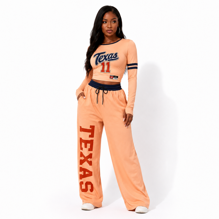 Angled view of the nude-to-orange gradient women's two piece set with cropped top, wide-leg pants, and visible print details.