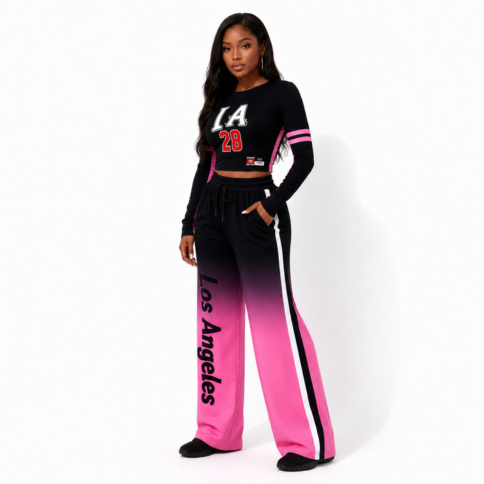 Three-quarter view of black-to-pink gradient women's two piece set with cropped top, wide-leg pants, and visible print detail