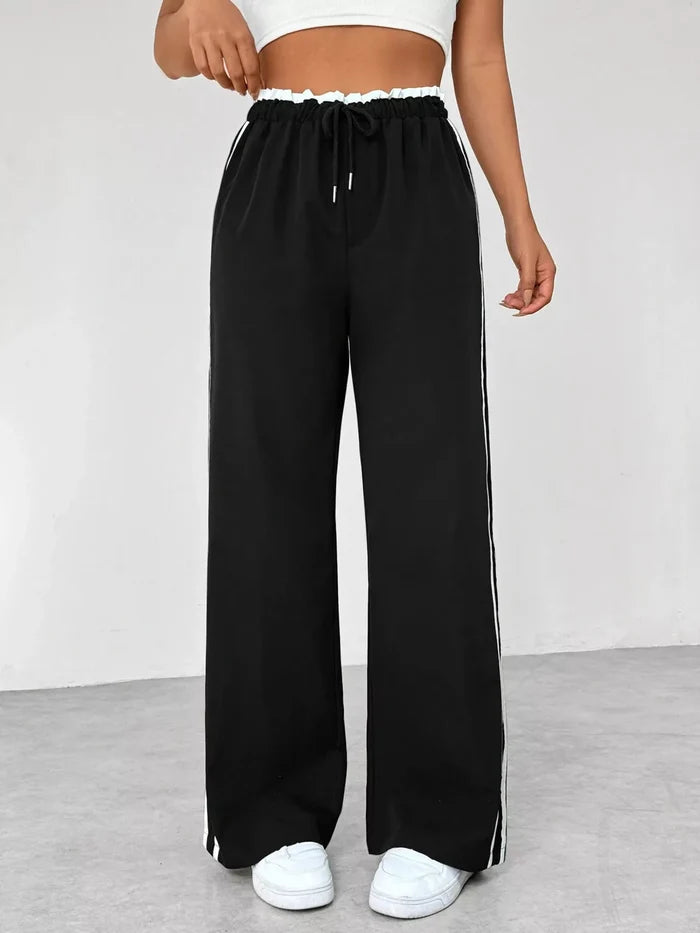 Black wide-leg pants with white stripes on a plain background